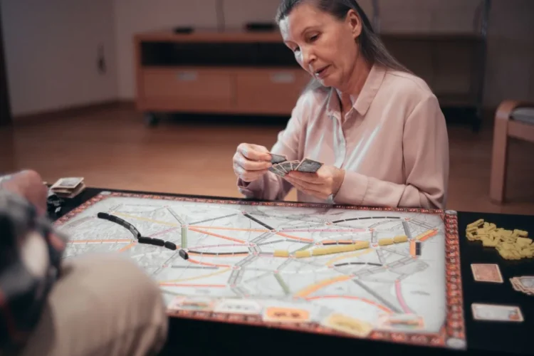 Personne âgée jouant à un jeu de société pour stimuler la mémoire