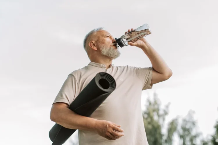 Senior buvant de l’eau après une activité physique douce